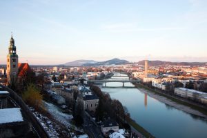 Photo over the Salzach river in Salzburg, with a bridge and urban scenery on either side